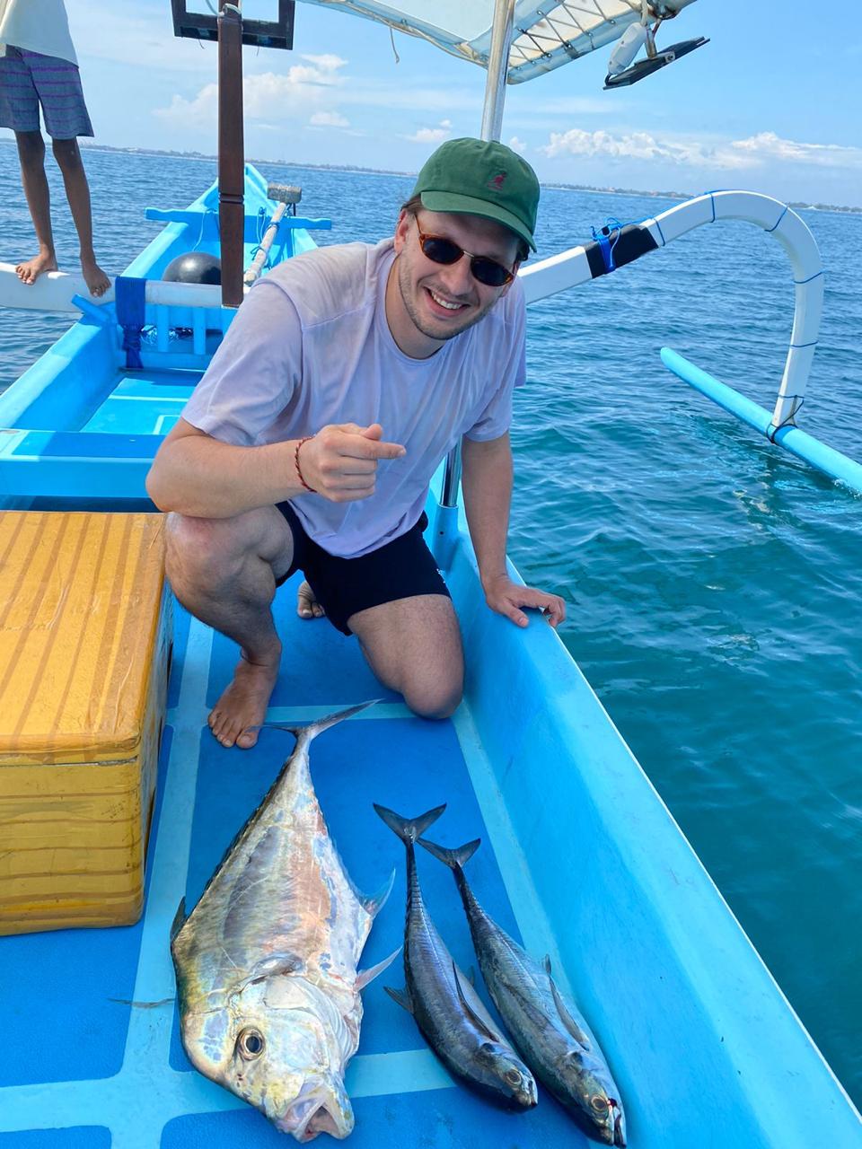 First Mate Wayan with a silver fish on the boat