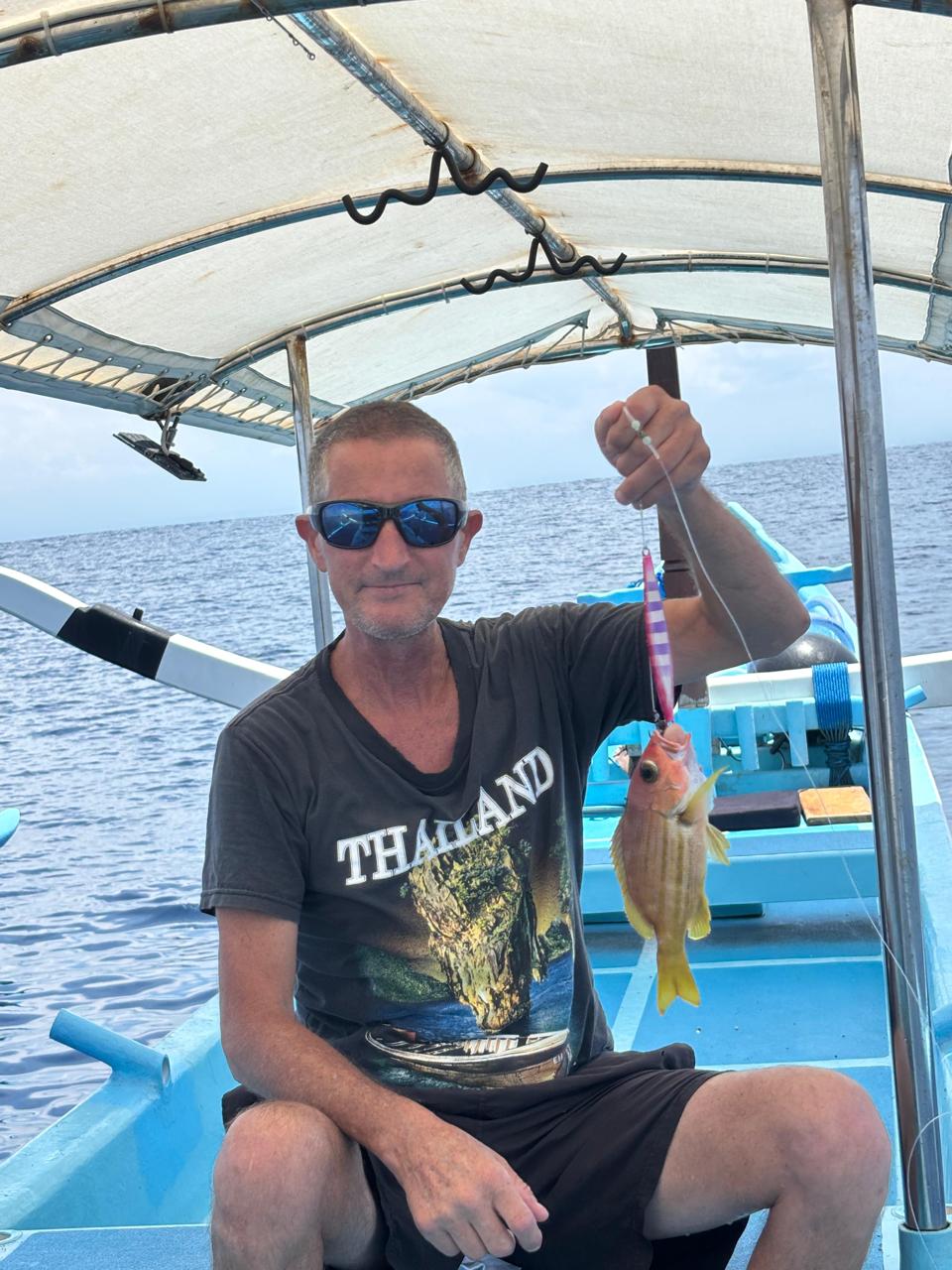 Client with a jigging catch on a Bali fishing trip