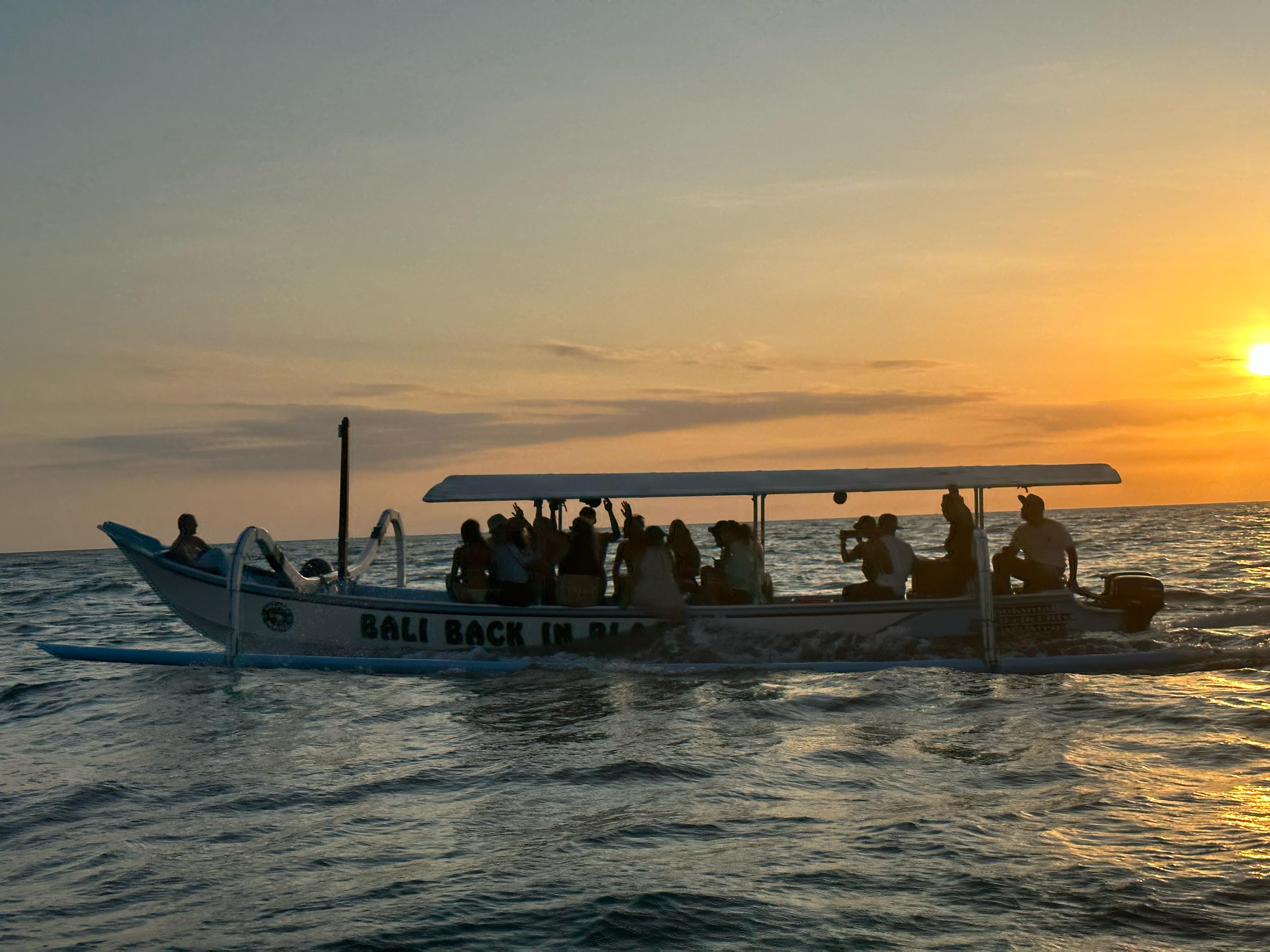 Guests silhouetted on the boat at sunset